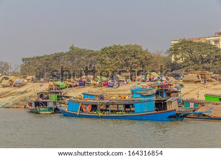 MANDALAY - FEBRUARY 26: Lot of transport ships in harbor on the bank of the Irrawaddi river on February 26, 2013 in Mandalay, Myanmar.