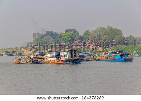 MANDALAY - FEBRUARY 26: Lot of transport ships in village harbor on the bank of the Irrawaddi river on February 26, 2013 in Mandalay, Myanmar.
