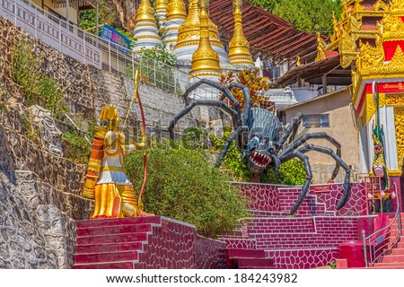 PINDAYA, MYANMAR - FEBRUARY 27, 2013: Representation of the legend at the entrance pilgrimage caves where young Prince Kummabhaya killed giant spider to save seven princesses.