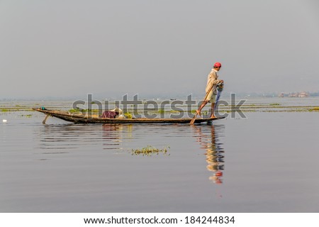 INDEIN, MYANMAR - FEBRUARY 28, 2013: Leg rowing fishermen on Inle Lake who row traditional wooden boats using their leg and fish using nets.
