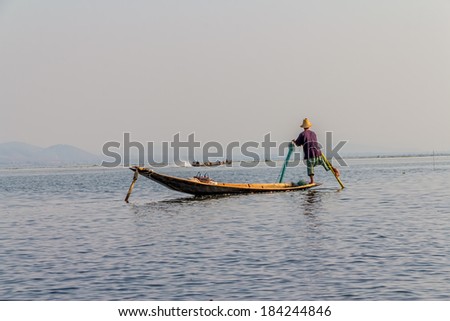 INDEIN, MYANMAR - FEBRUARY 28, 2013: Leg rowing fishermen on Inle Lake who row traditional wooden boats using their leg and fish using nets.