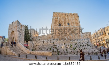 JERUSALEM, ISRAEL - FEBRUARY 28, 2014: Priest and tourists passing by The Tower of David. It is an ancient citadel located near the Jaffa Gate entrance to the Old City of Jerusalem.