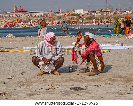 HARIDWAR, INDIA - APRIL 12, 2010: Two friends talking by the Ganges River at the Kumbh Mela - is a mass Hindu pilgrimage of faith in Which Hindus gather to bathe in the sacred river.