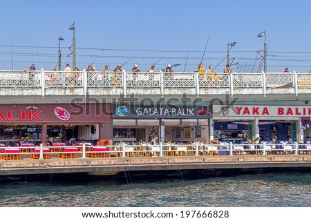 ISTANBUL, TURKEY - SEPTEMBER 29, 2013: Looking towards the Galata bridge with lot of fishermans fishing with rods and seafood restaurants from the boat.