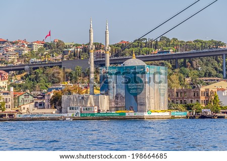 ISTANBUL, TURKEY - SEPTEMBER 29, 2013: View of the Ortakoy Mosque in restoration and First Bosphorus Bridge, sailling Bosporus.