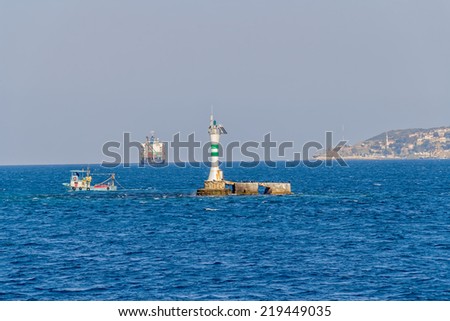 Fishing boat near Lighthouse at the entrance to the Black sea.
