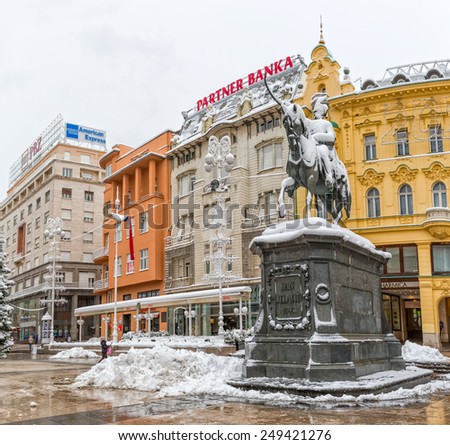ZAGREB, CROATIA - December 28, 2014: Winter scene of the main square Ban Jelacic with sculpture covered with the snow.
