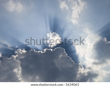 Sun is hiding behind a cloud with light streaks all around.