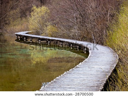 Curved wooden path in the Plitvice lakes (Plitvicka jezera) national park, Croatia, Europe. Season: Early spring.