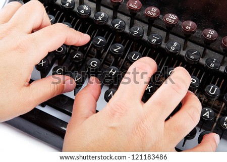 Female hands typing on the keyboard of the old mechanical typewriter.