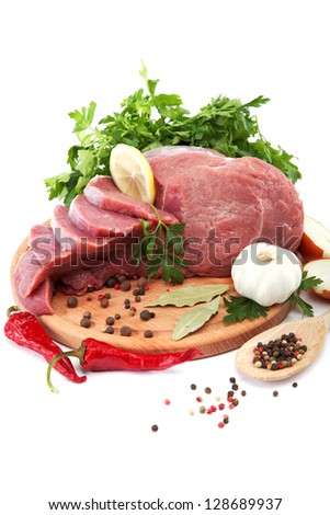 Raw meat, vegetables and spices on a wooden cutting board isolated on white background.