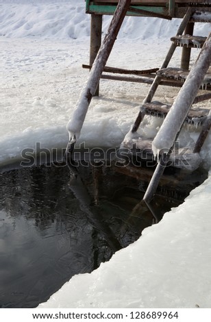 Staircase and a ice hole for the winter swimming at the river.