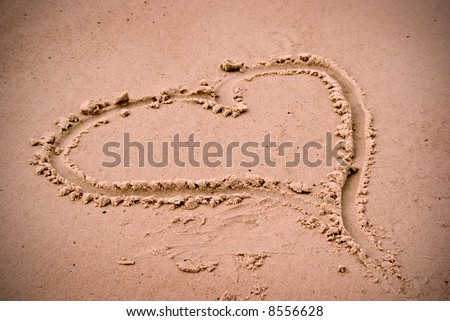 stock photo : a love heart drawn in the sand at the beach