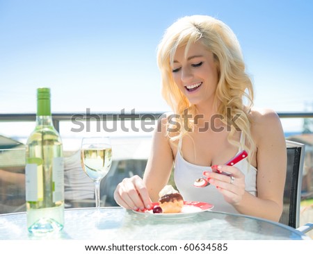 beautiful young woman with wine and profiterole