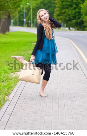 happy young woman jumps up on the footpath
