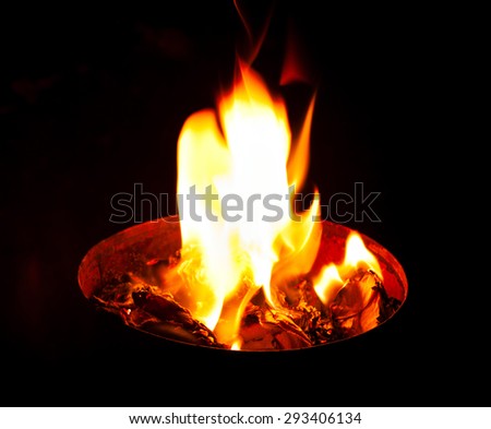 white flame comes out of the container, filled with burning coals