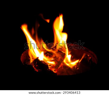 yellow flame comes out of the container, filled with burning coals