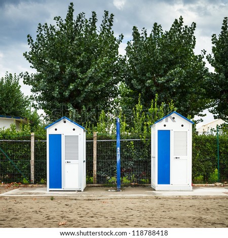 Changing rooms at the one of the Garda lakes beach with a green trees on a background