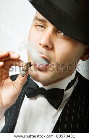 Good looking man with cigar dressed like old fashion gangster