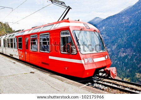 red Swiss train at hill side railroad
