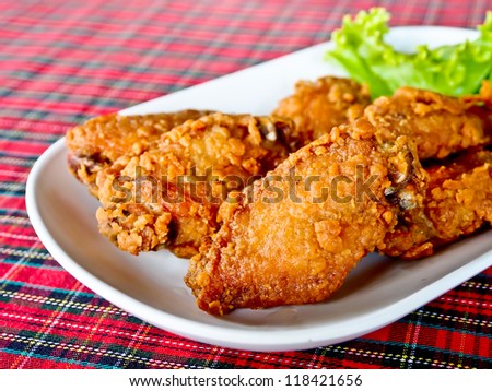 fried chicken's wings in a white dish