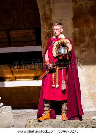 BATH, UNITED KINGDOM - APRIL 11, 2015: Actor in Roman soldier costume at history site Roman Bath. The Baths are a major tourist attraction receiving more than one million visitors a year.