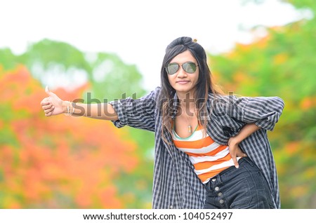 an asian attractive delight girl travelling by thump up with casual sexy wear on blur forest background