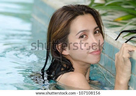 Asian woman in bikini on pool