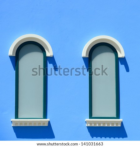 Windows on blue wall in sunny day