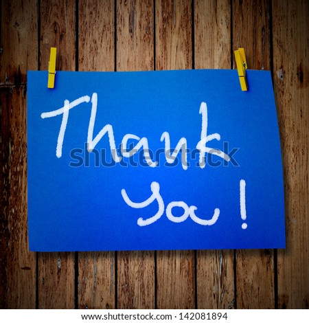 note paper and clothes peg on a wooden background with Thank you