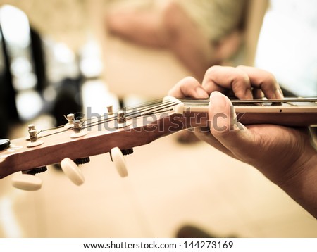 A man plays an acoustic guitar close-up
