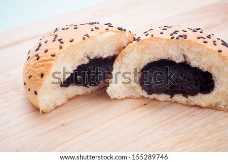 buns with sesame seeds and black eyed pea on wooden background