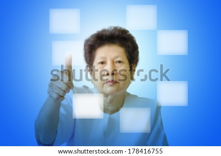 Asian senior woman pointing on transparent virtual screen, space for text/button