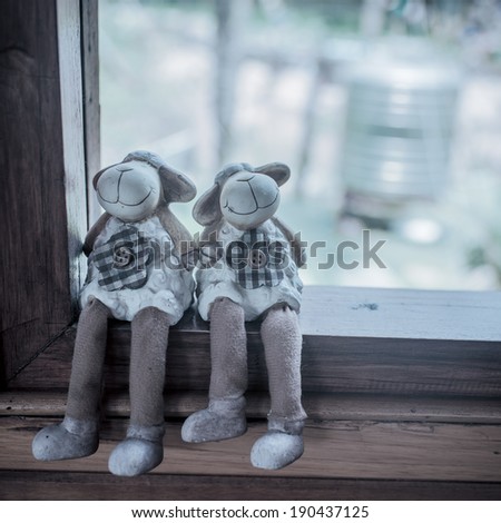 Couple of sheep dolls sitting on window, love concept process in pastel.