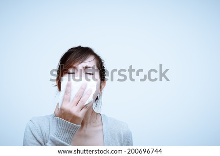 Sick woman blowing her nose isolated.