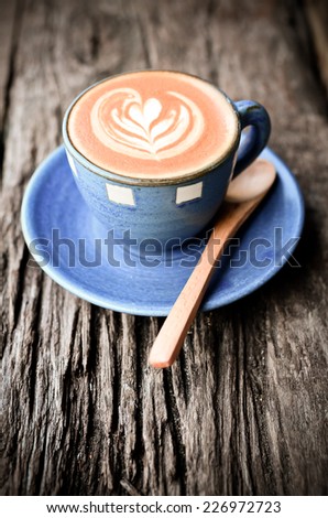 Latte art, Blue coffee cup on wooden background with vintage colour effect