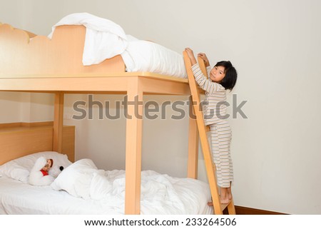 Happy child in child's room on a bunk-beds