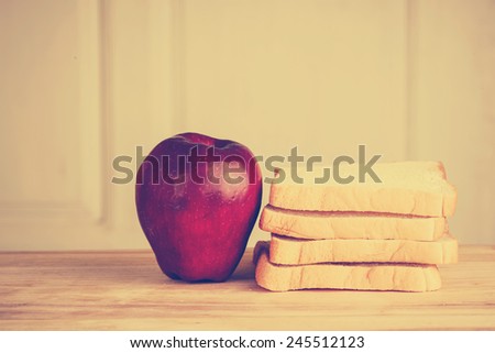 apple, bread on wooden floor, photo filter effect.