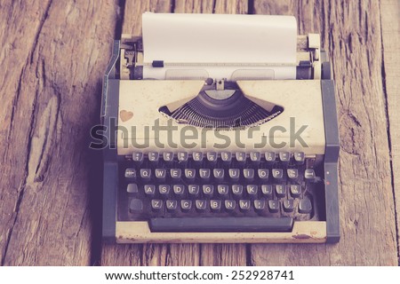 vintage typewriter and telephone , notebook on the wood desk in vintage tone.