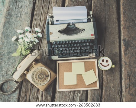 vintage typewriter and telephone and happy coffee mug on the wood desk in vintage color tone