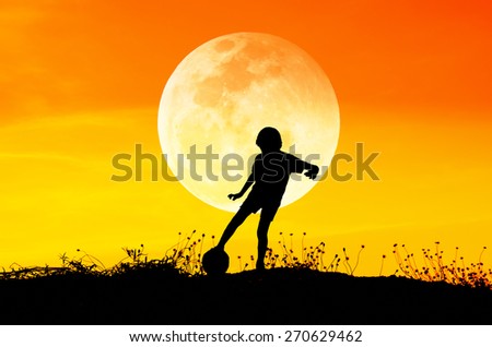 Silhouette of soccer man playing with the ball and big moon.
