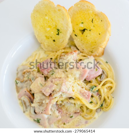 Spaghetti, cheese, bacon and mushrooms in white disk
