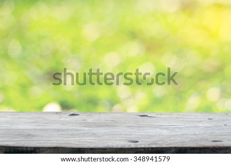 Empty wooden deck table with green background. Ready for product display montage