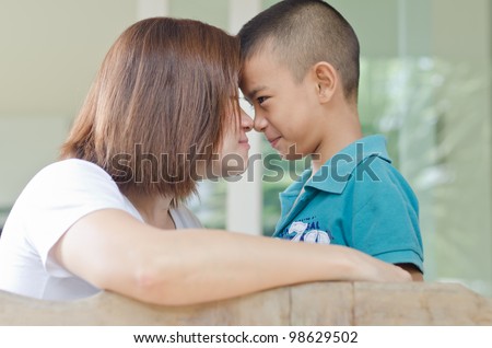 Single Mom kiss her son in front of house