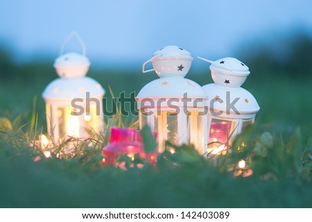 Romantic candle decoration in the summer grass in the evening.
