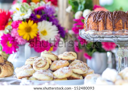 Table full of homemade cakes and cookies - colorful flower decoration