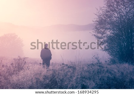 Lonely person in the morning mist. Landscape composition.
