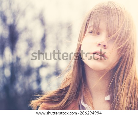 Carefree Young Woman with Windy Hair Outdoors