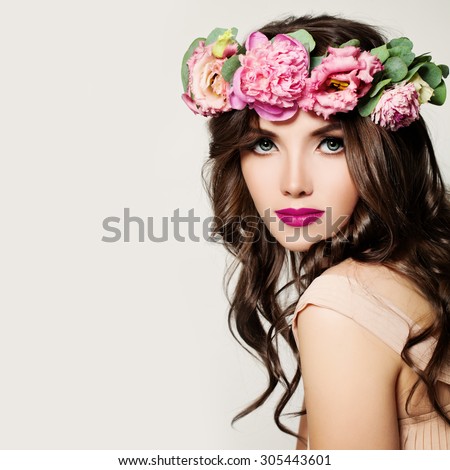 Fashion Woman. Girl with Makeup, Curly Hair and Pink Flowers