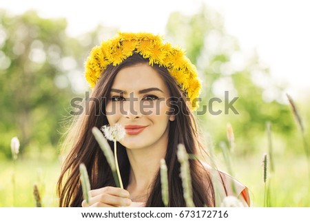 Fashion Summer Model Girl with Long Blowing Hair. Summer Beautiful Woman with Healthy and Beauty Brown Hair with Green Grass on Sunny Background